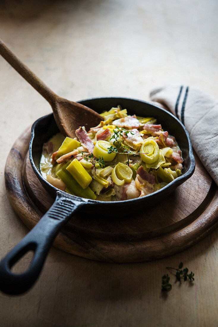 Creamy leeks with bacon in a small cast iron frying pan