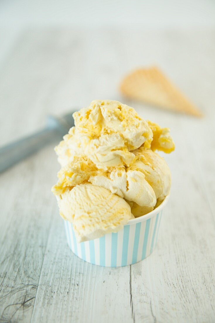 Lemon meringue ice cream in a striped tub