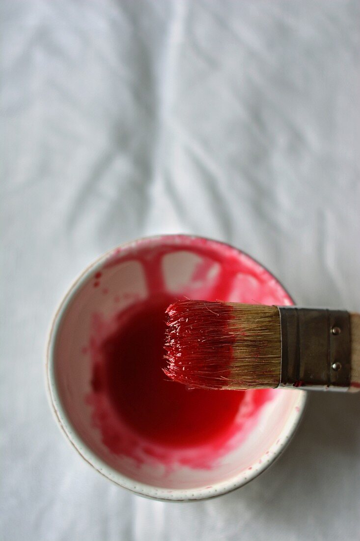 Rhubarb cordial in a small bowl with a brush