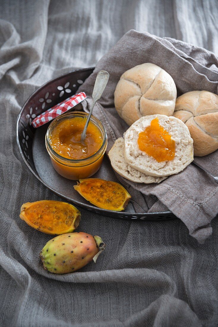 Homemade vegan prickly pear jam with crusty bread roll halves