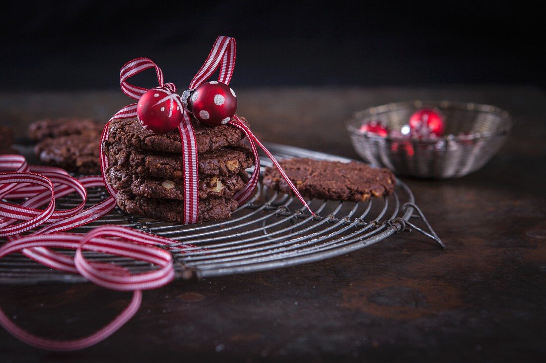 Christmas chocolate and walnut cookies wrapped in gift ribbon with a bauble decoration