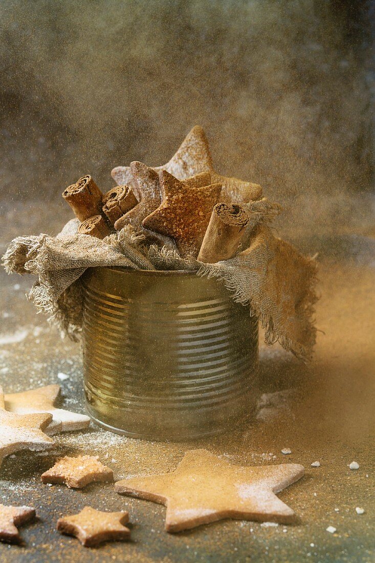 Homemade shortbread star shape sugar cookies with sugar and cinnamon sprinkling powder in old tin can