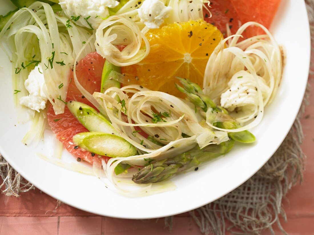 A plate of salad with fennel, citrus fruits and fried green asparagus