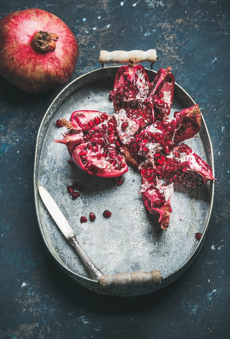 Fresh ripe pomegranate in vintage metal tray