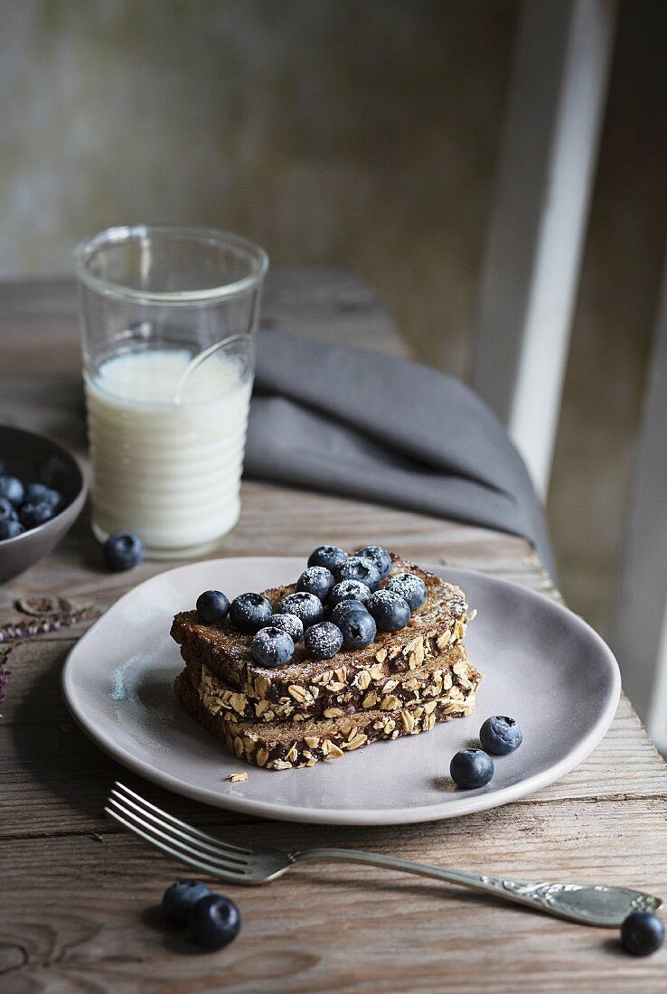 Breakfast with cereal bread and blueberries on wooden table