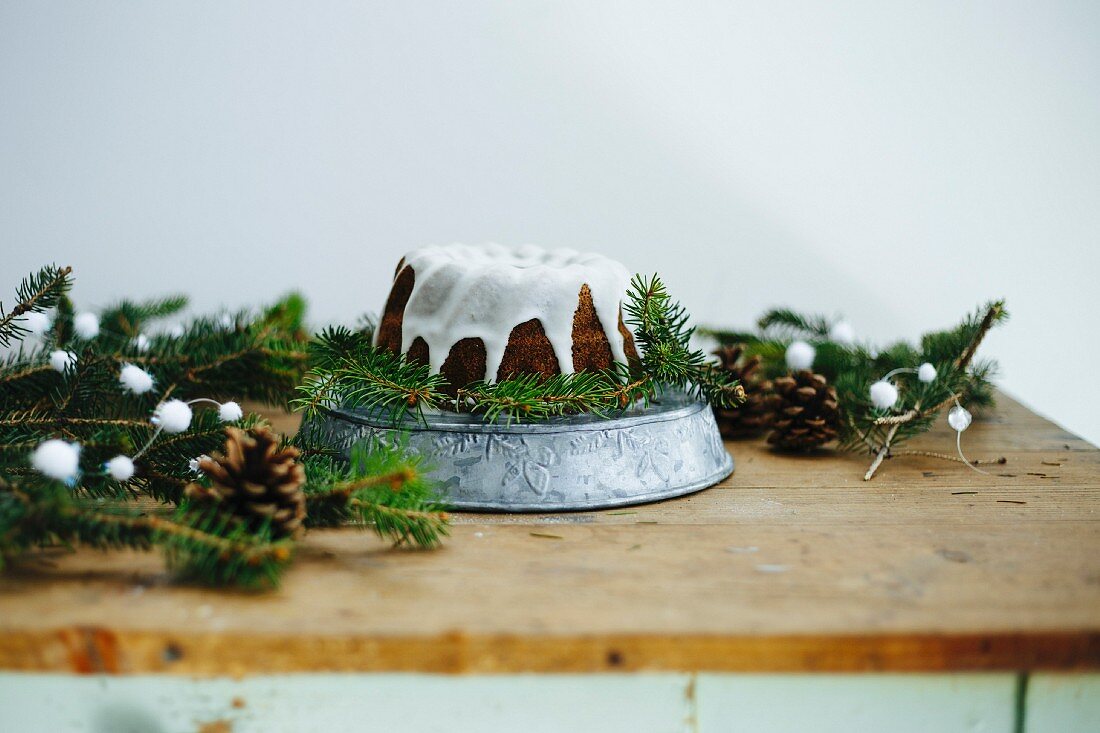 Kuchen mit Zuckerglasur auf weihnachtlich dekoriertem Tisch