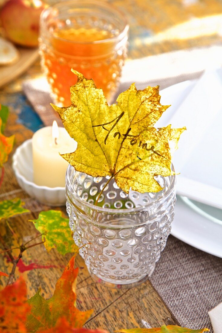 Herbstliches Tischgedeck mit Laubblatt als Namensschild