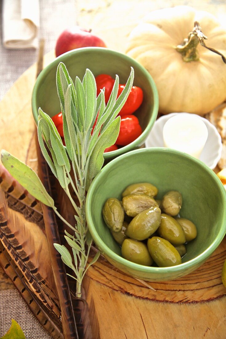 Oliven und Tomaten auf herbstlich gedecktem Tisch