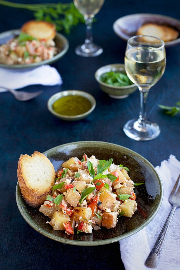 Bratkartoffeln mit Zitrone, Feta, Paprika und Petersilie, dazu Brot und Weißwein