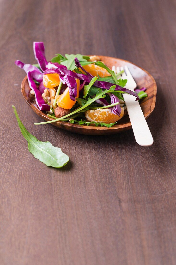 A rocket and red cabbage salad with nuts, wheat and tangerines