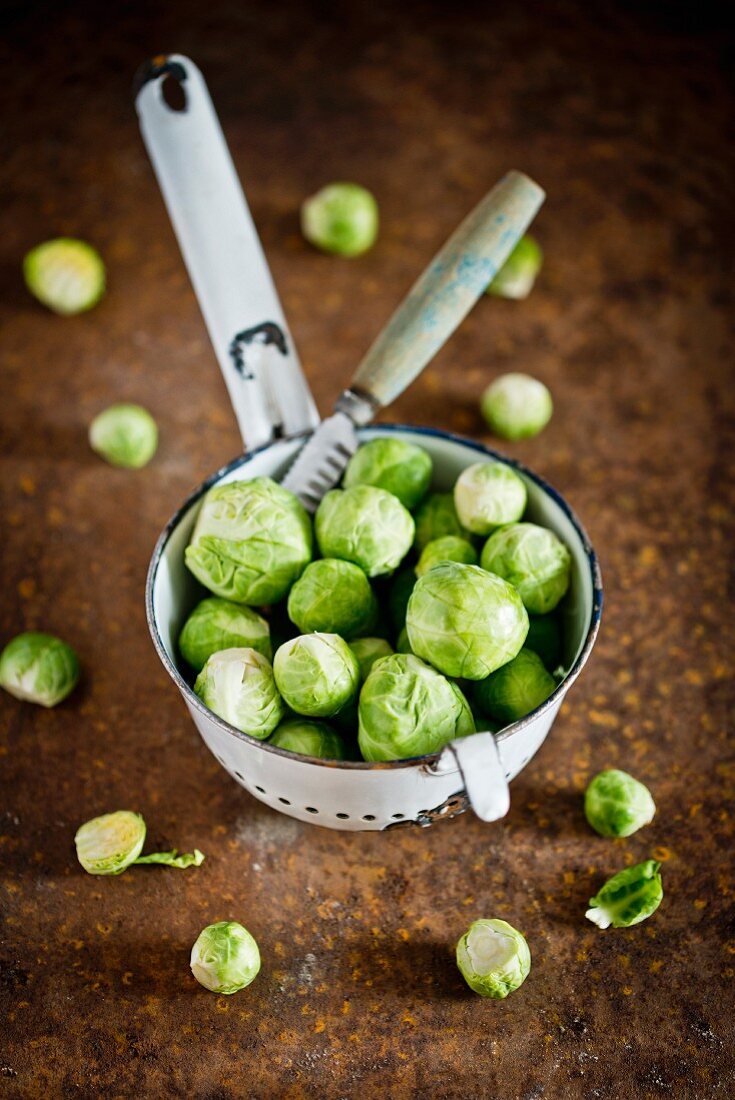 Frischer Rosenkohl im Küchensieb mit Messer