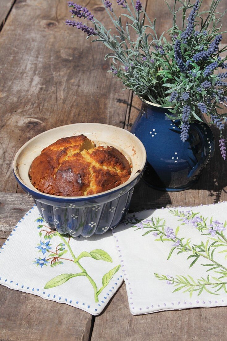 DIY-Topflappen und Keramikgefässe mit Kuchen und Lavendel auf Holztisch