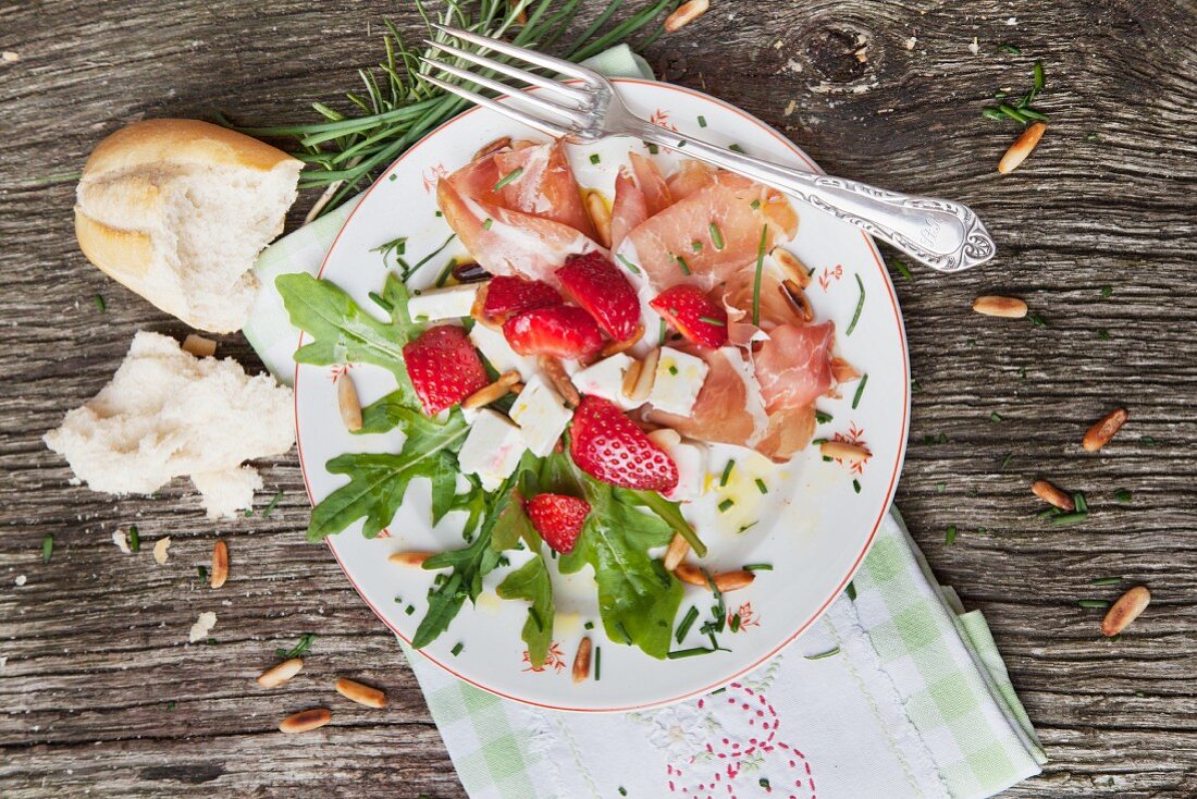 Parma ham with strawberry salad and roasted pine nuts