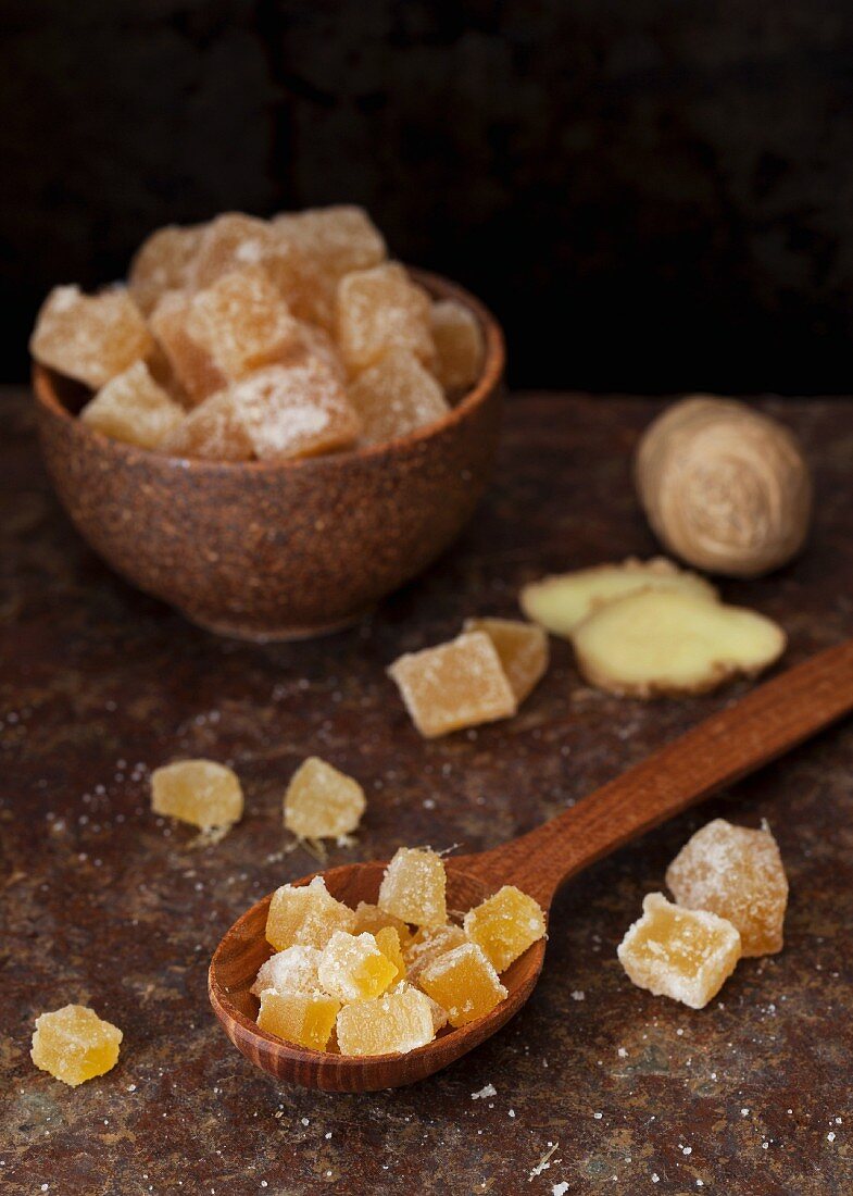 Candied ginger in a bowl and on a wooden spoon