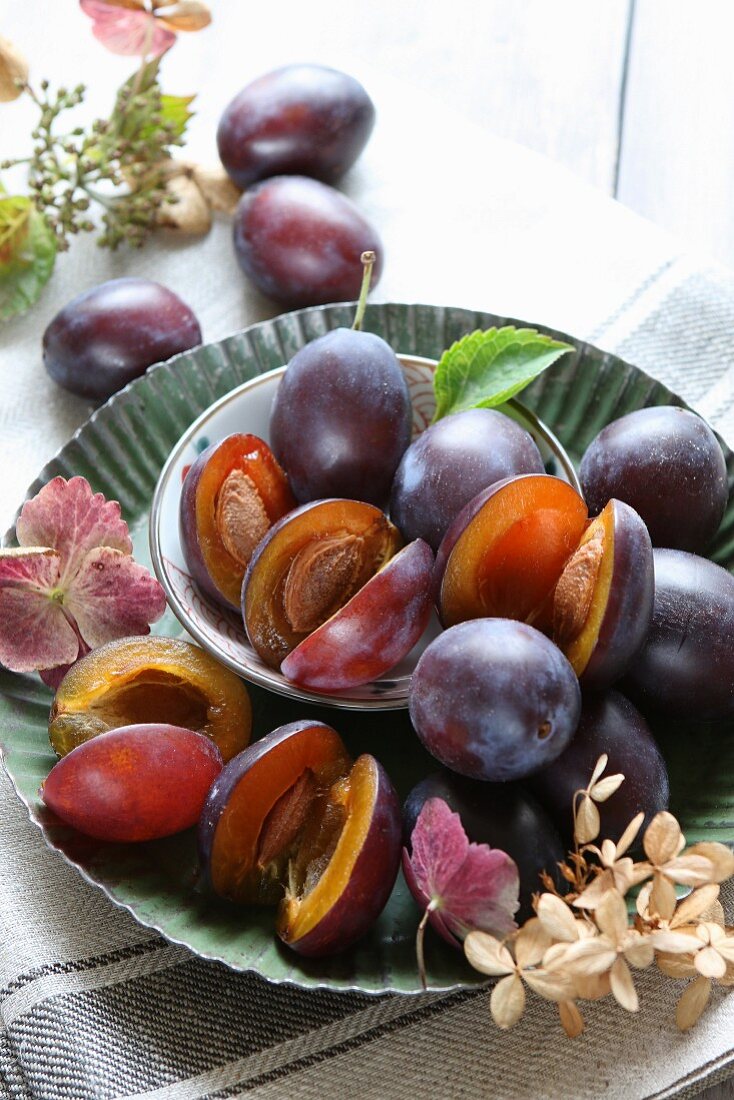 Fresh plums in a bowl on a metal plate