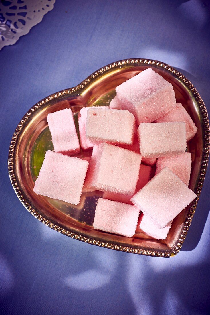 Rosa Marshmallows auf herzförmigem Teller