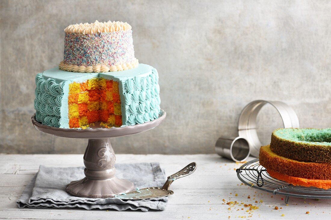 Brightly coloured two-tier checkerboard cake with buttercream