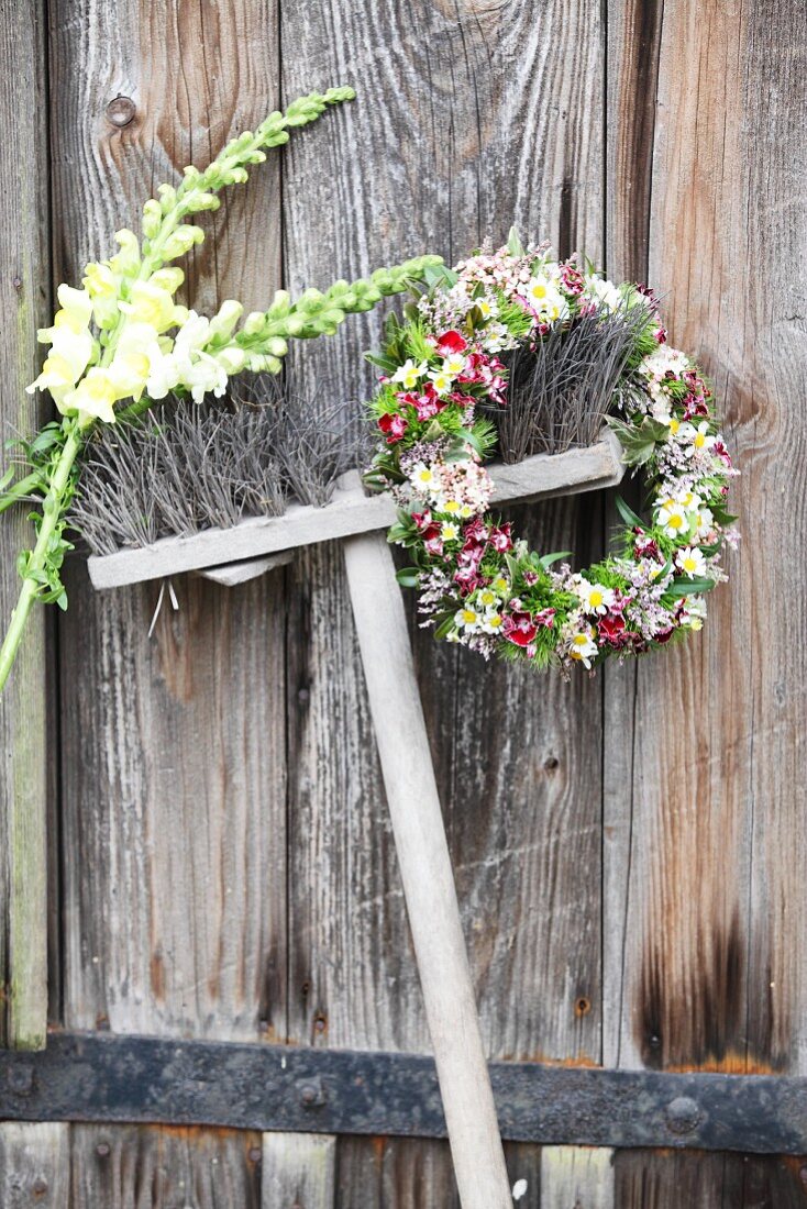 Flower wreath and two snapdragons hung from broom