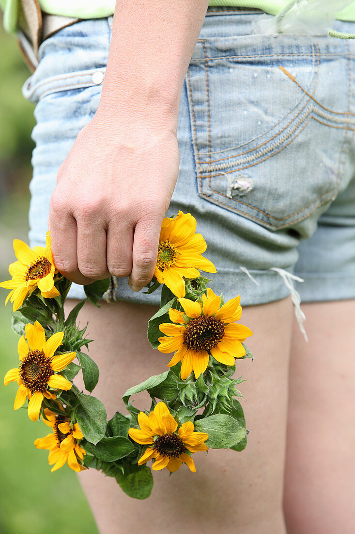Wreath of sunflowers held in woman's hand