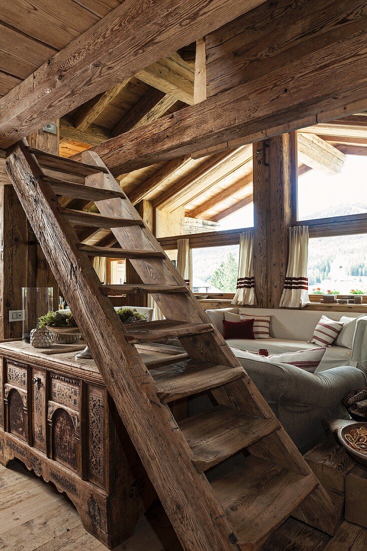Rustic wooden staircase and trunk in living area of chalet
