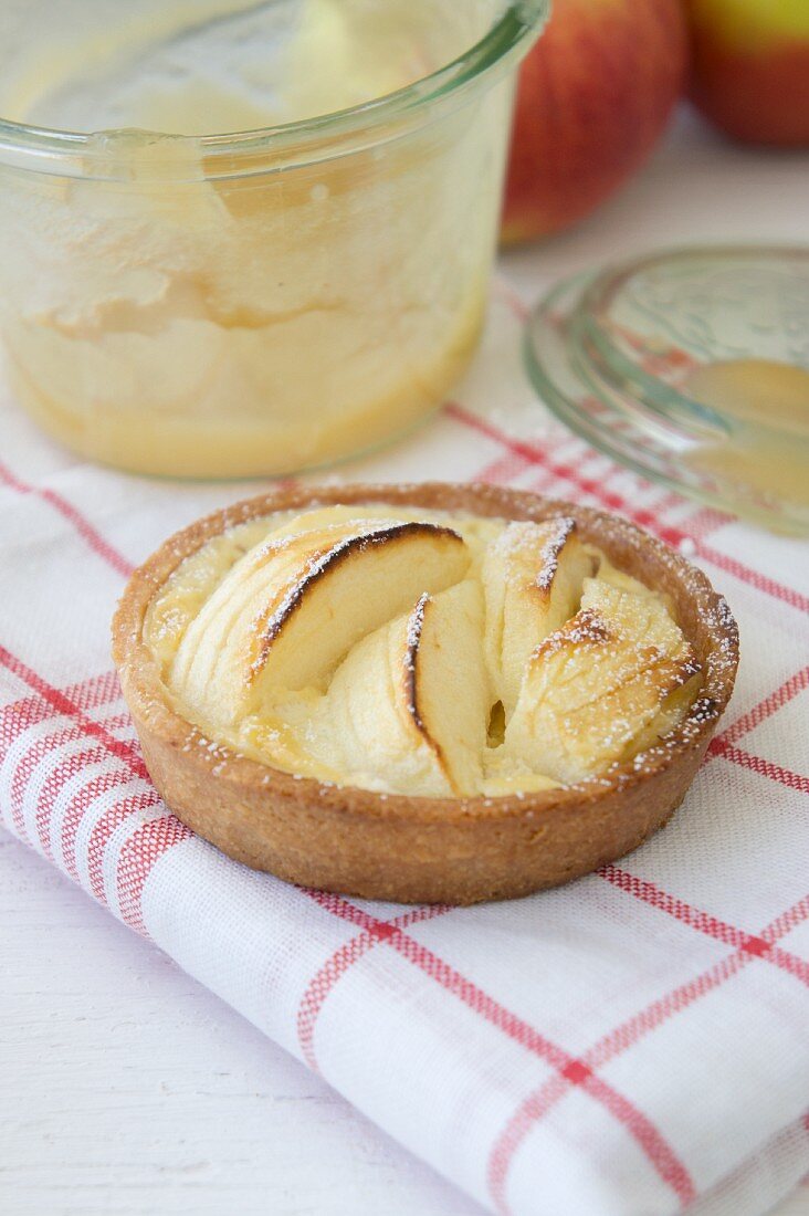 An apple tartlet on a kitchen towel