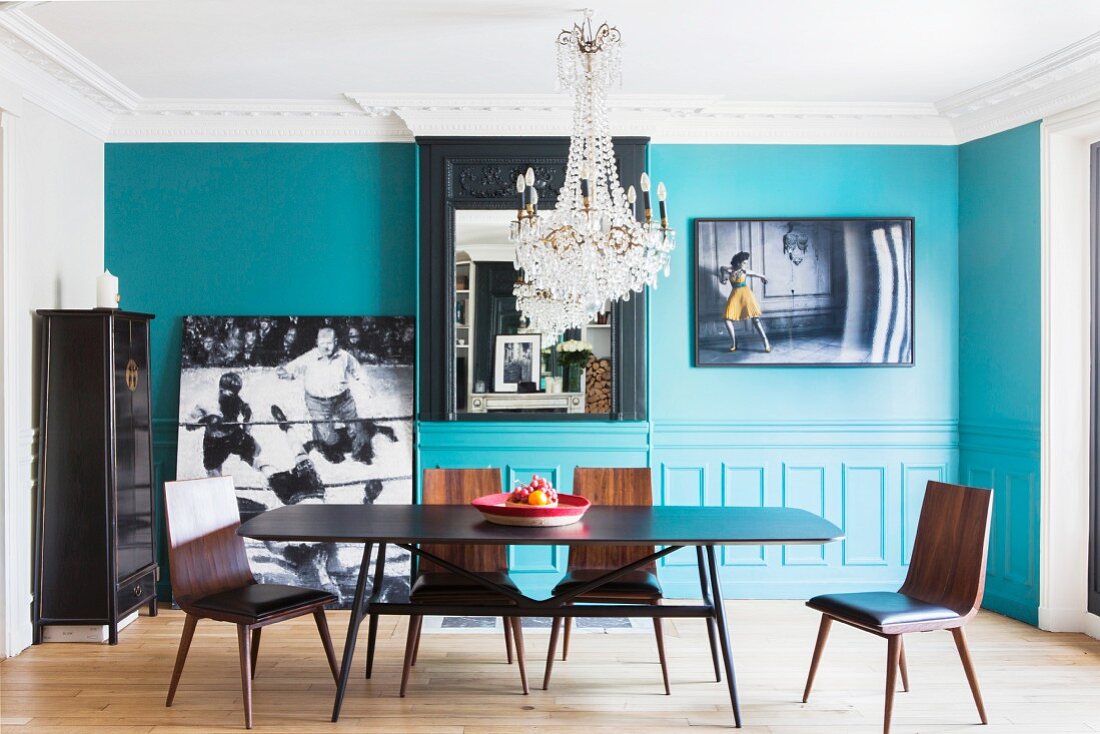 Turquoise wall and crystal chandelier in dining room