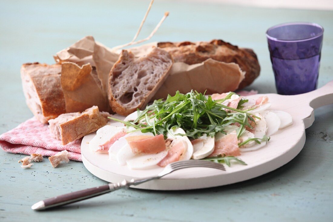 Turnip carpaccio with ham, mushrooms and arugula, served with French bread