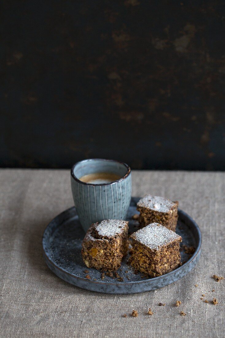 A brownie with small cup of cappuccino on a linen blanket