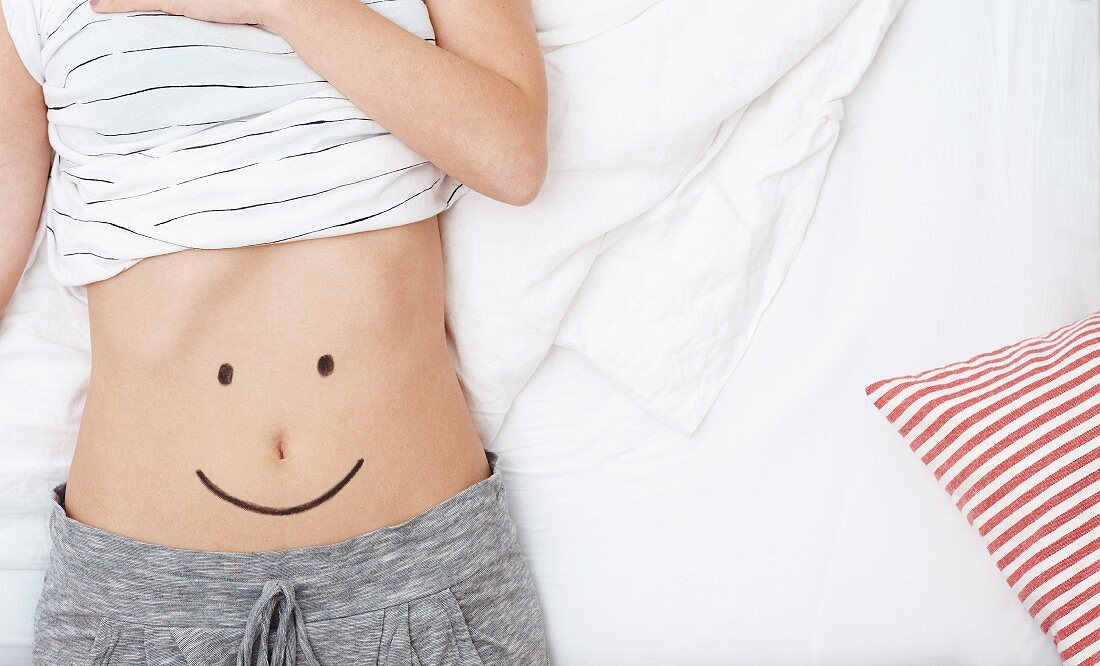 A smiley face drawn on a woman's stomach