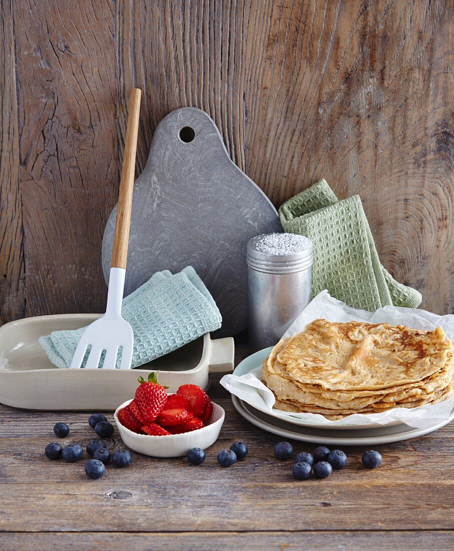 Pancakes with berries and cooking utensils