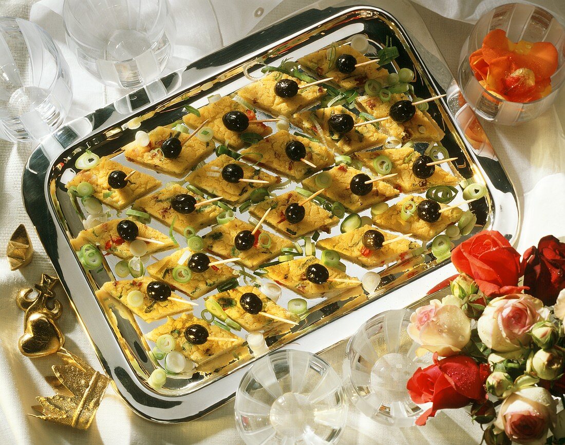 Polenta rhombuses with black Olives as party bite-size Snacks Tray