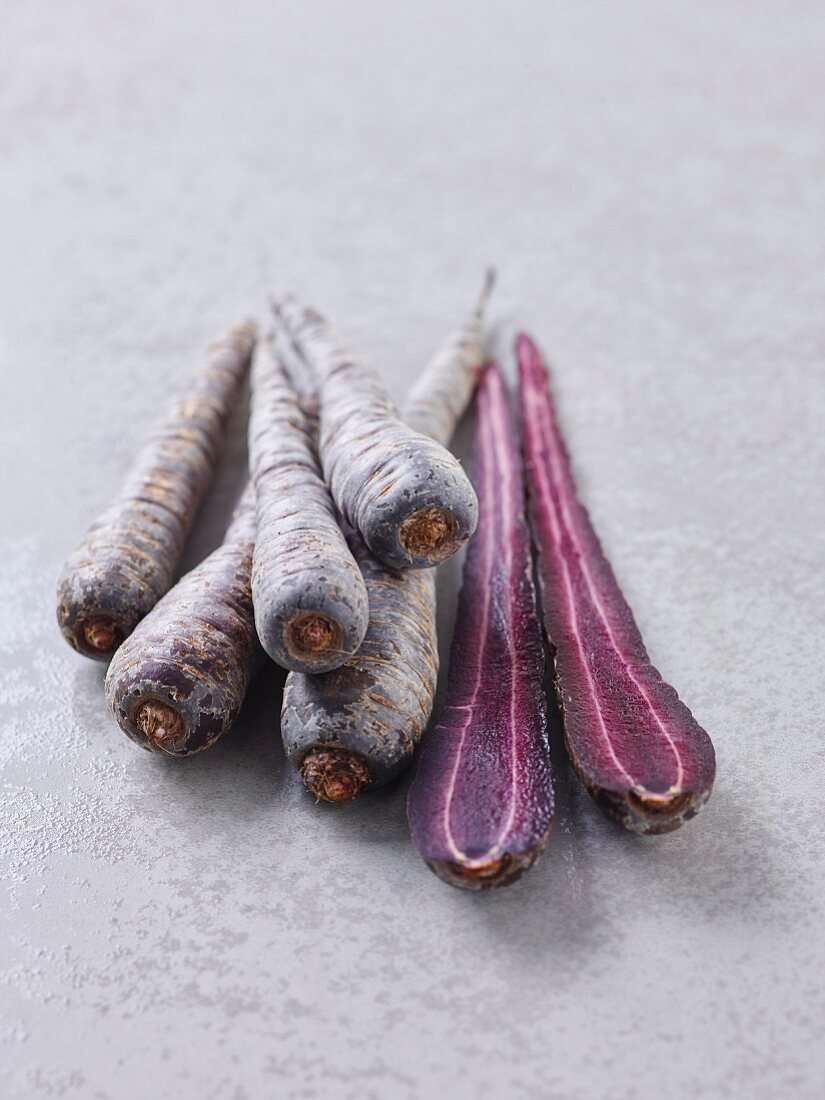 Whole and halved purple carrots