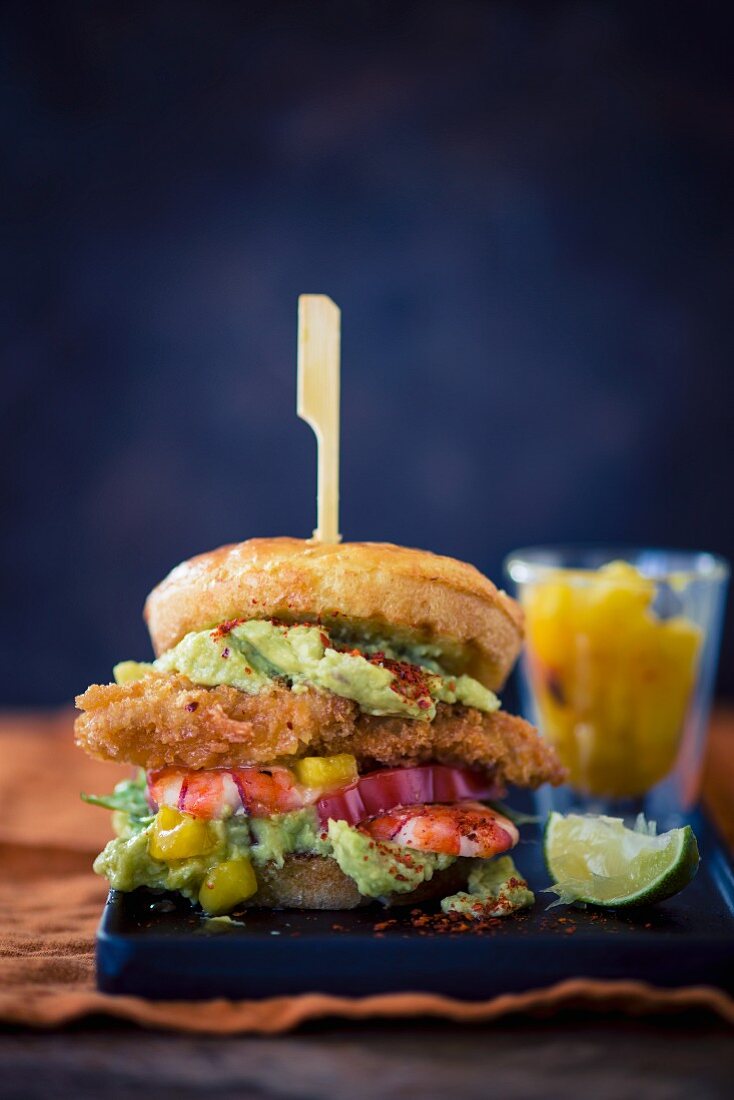 A burger with chicken breast, pineapple, avocado, prawns and mango chutney