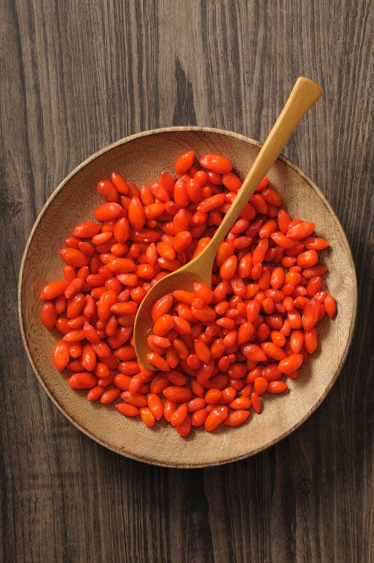 Goji berries in a wooden bowl with a spoon