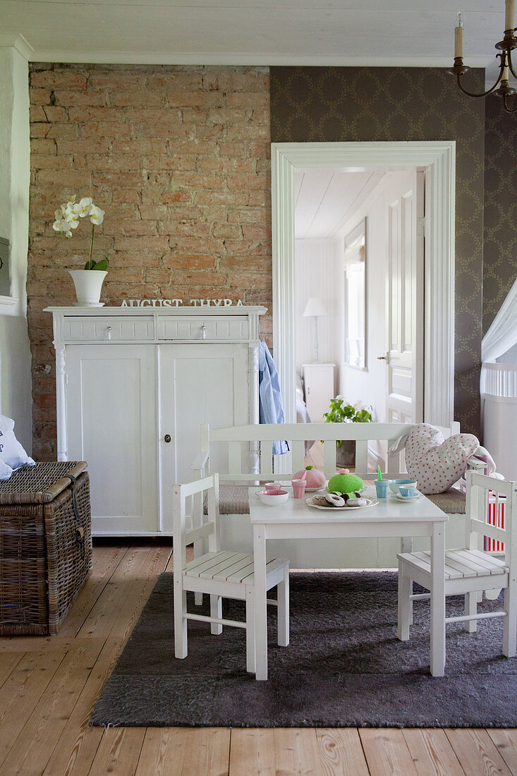 Tisch und Stühle im Kinderzimmer mit Backsteinwand