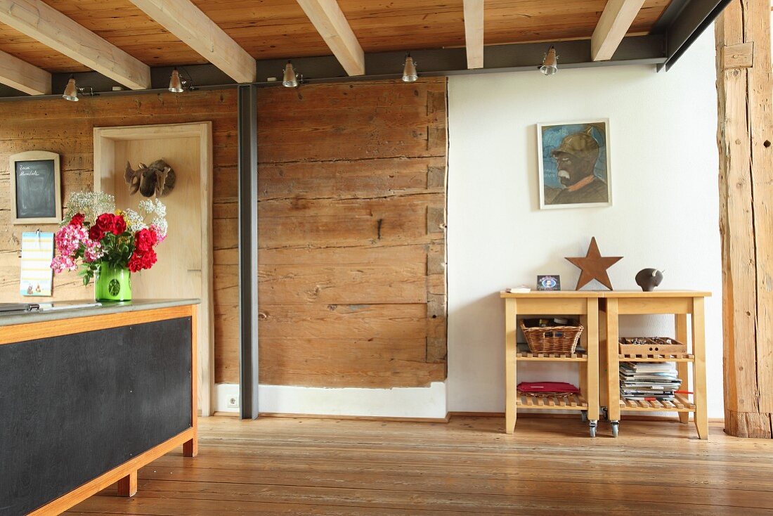 Steel beam and pillar against solid wooden wall in open-plan living area