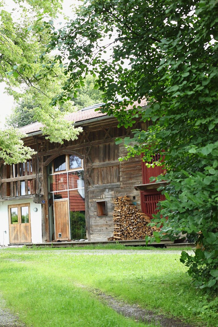 Modernised barn with tall window and traditional half-timbered frame