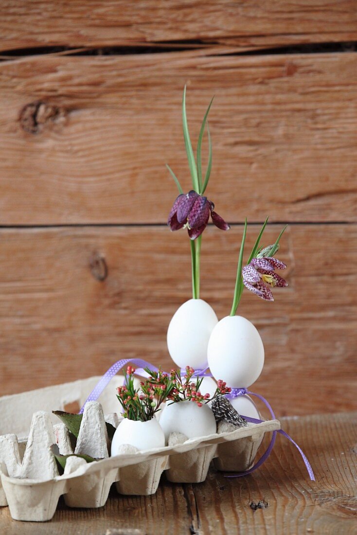 Blumendeko in ausgeblasenen Eiern im Eierkarton