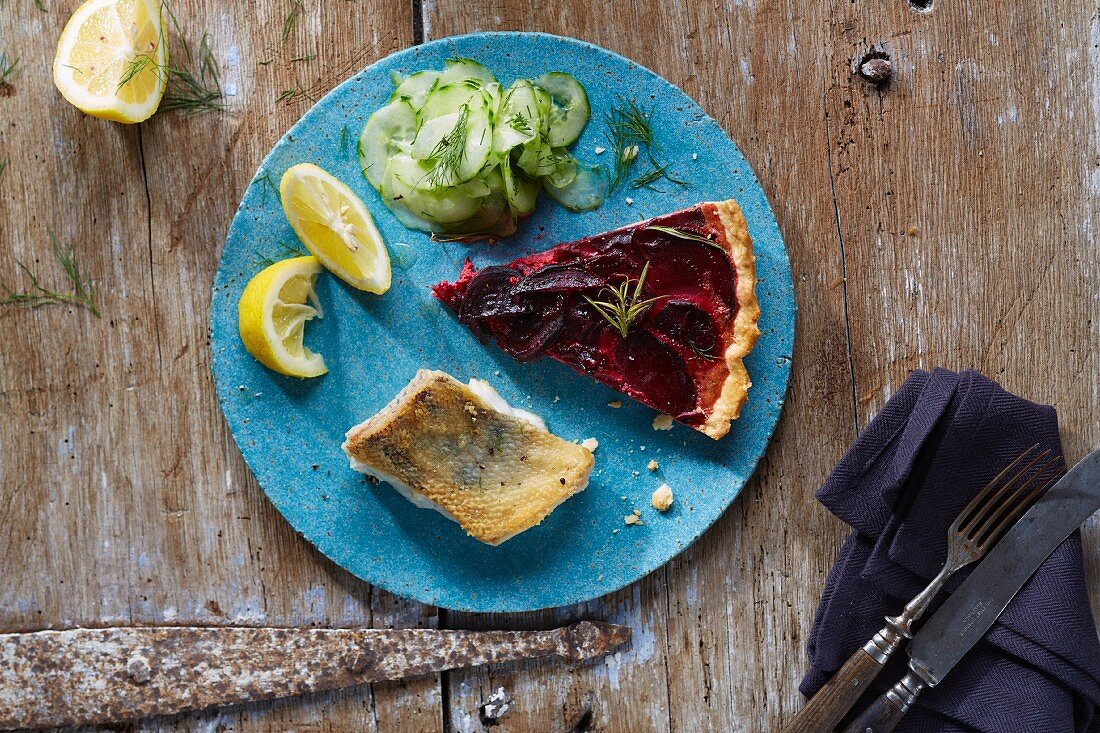 Beetroot quiche, fried fish fillet and cucumber salad