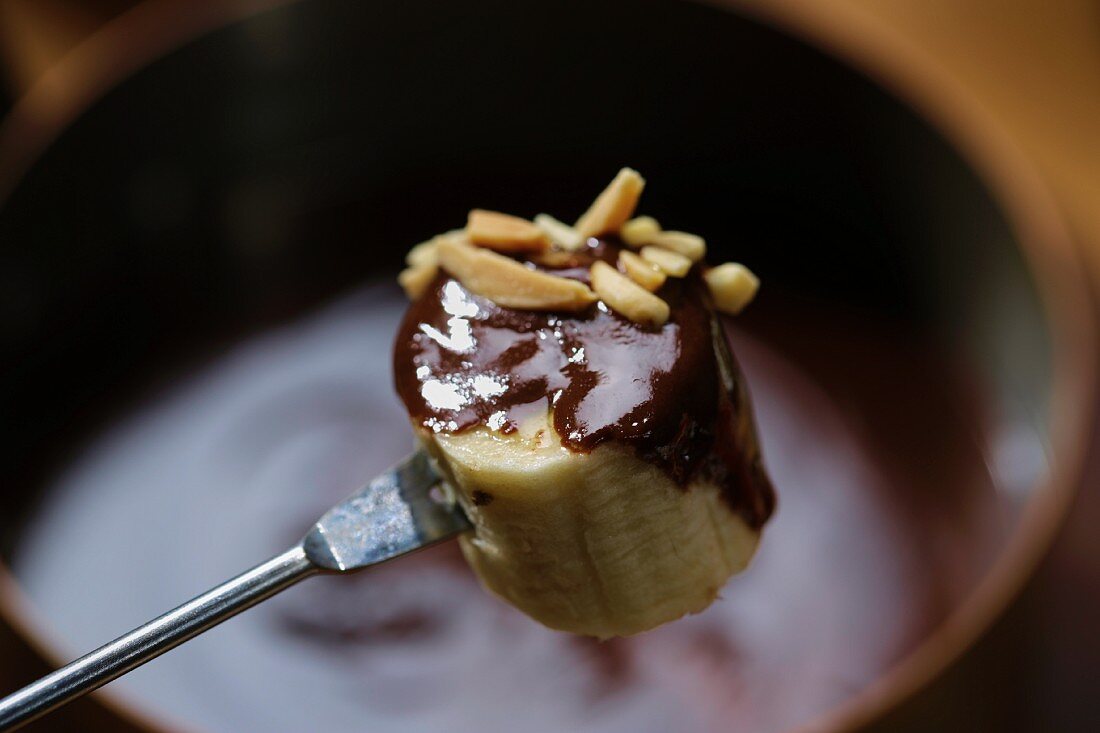 Chocolate fondue with banana and almonds