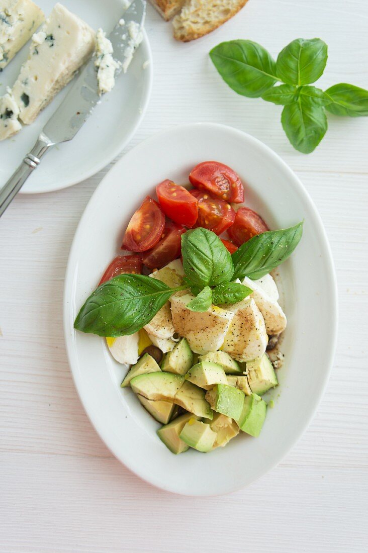 Tomatoes, mozzarella and avocado with basil