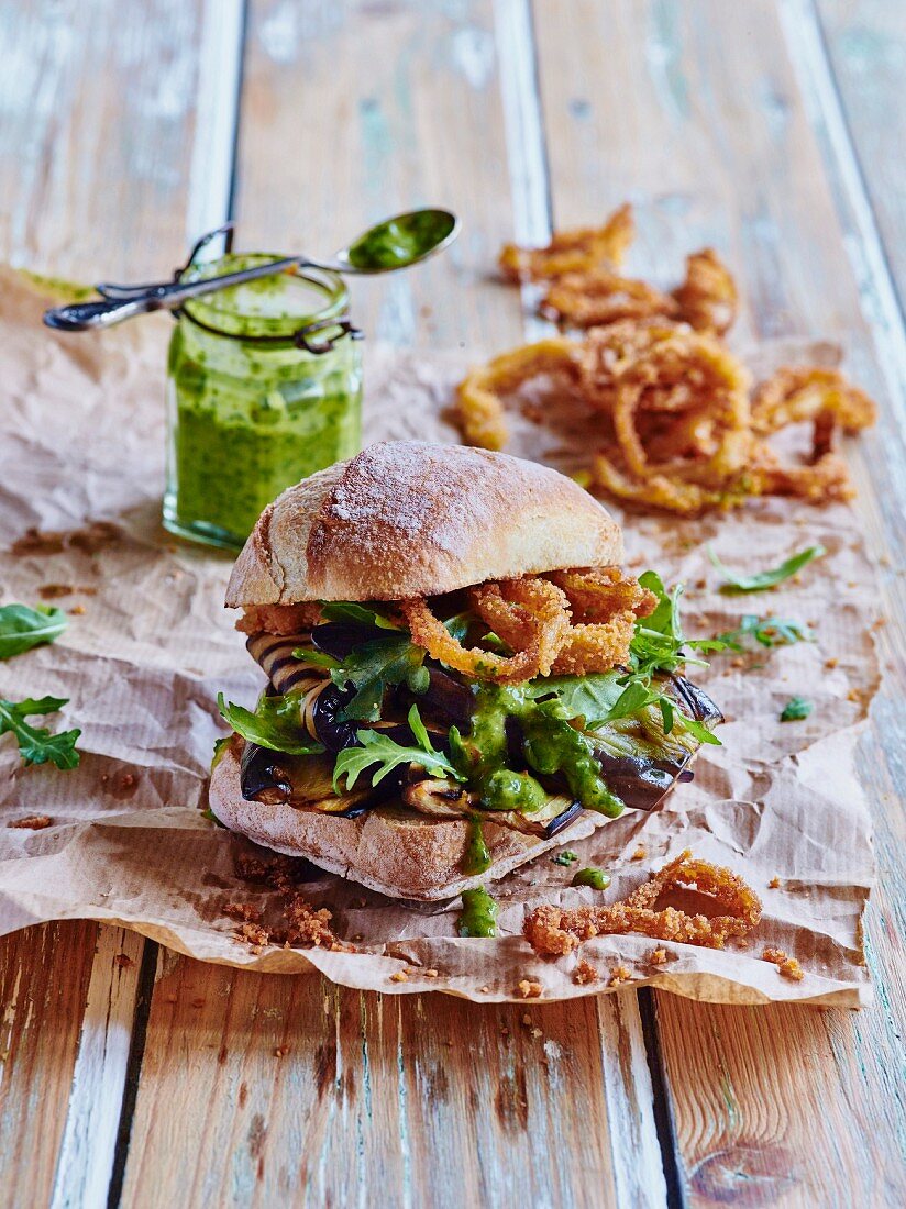 Burger with aubergines, crispy onion rings and chimichurri