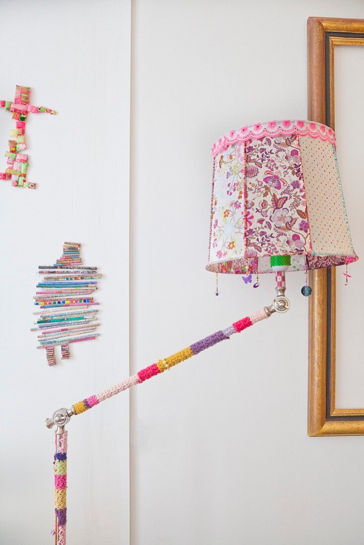 Standard lamp with crocheted cover on stand and floral lampshade