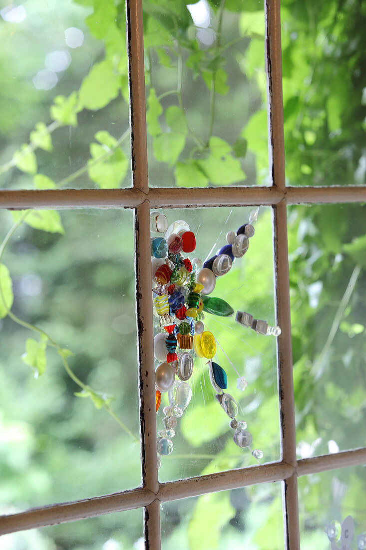 Window decorated with mosaic of beads