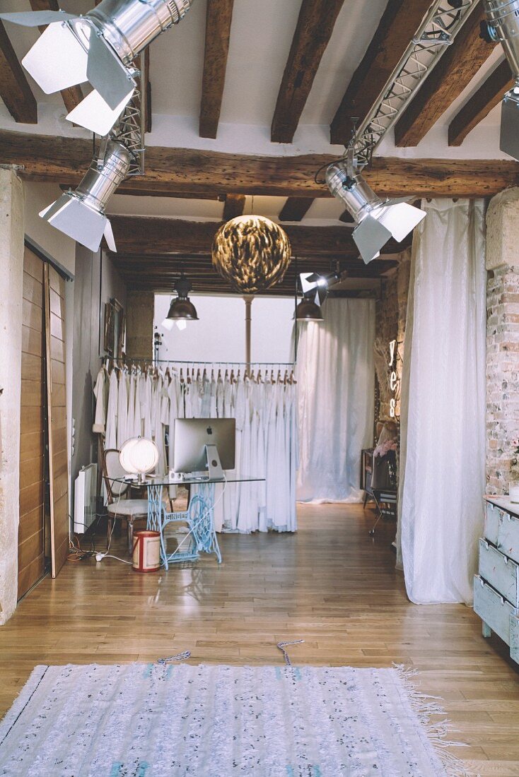 Bekleidungsgeschäft im Industriestil mit Studiolampen und Holzbalken