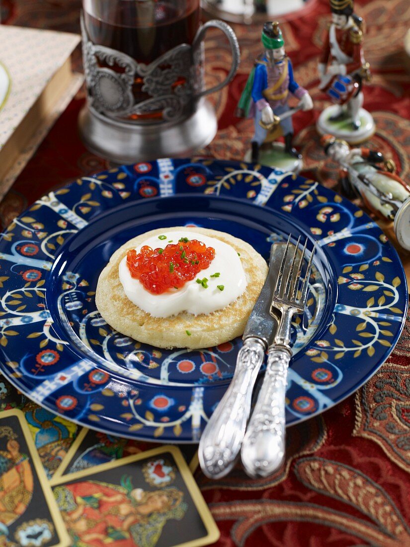 A blini with sour cream and caviar