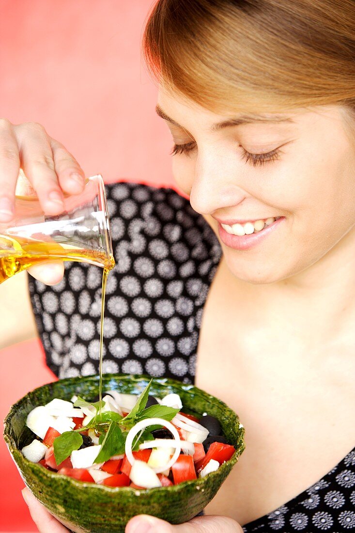 Woman adding olive oil