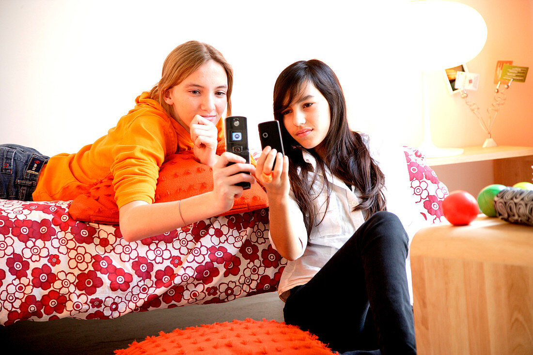 Two teenage girls reading SMS