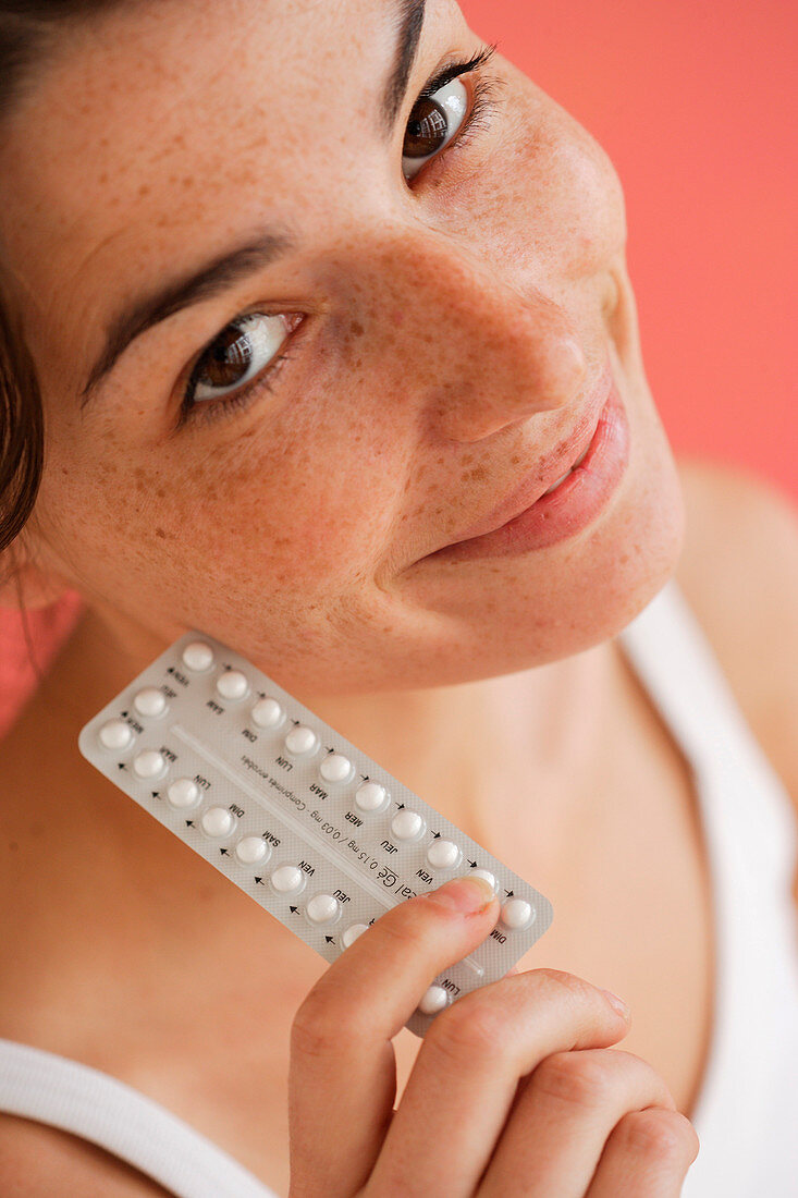 Woman holding contraceptive pills