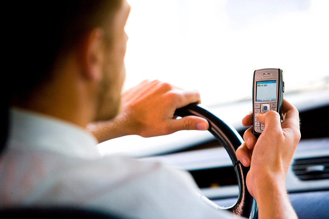 Man driving while using phone